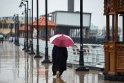 A person walks with an umbrella along a promenade by the Shatt al-Arab waterway in the southern Iraqi city of Basra following heavy rains across Iraq, on March 19, 2024. (Photo by Hussein Faleh / AFP) (Photo by HUSSEIN FALEH/AFP via Getty Images)