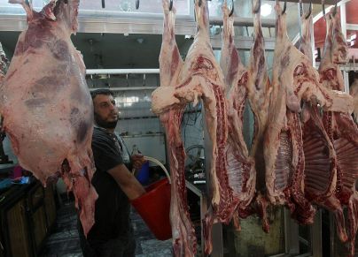 An Iraqi butcher works near hanging meat at a local market on July 6, 2014 in the capital Baghdad during the Muslim holy fasting month of Ramadan. AFP PHOTO/AHMAD AL-RUBAYE (Photo credit should read AHMAD AL-RUBAYE/AFP via Getty Images)