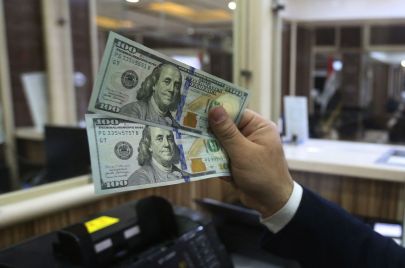 An employee counts banknotes at currency exchange shop in Baghdad on February 14, 2023. - Iraq nudged up the value of its local currency against the dollar in an effort to stabilise the dinar after tougher foreign transfer regulations sent its value fluctuating. The government adopted a new official exchange rate, fixing it at 1,300 dinars to the US dollar instead of 1,470, the prime minister's office said. (Photo by Murtaja LATEEF / AFP) (Photo by MURTAJA LATEEF/AFP via Getty Images)