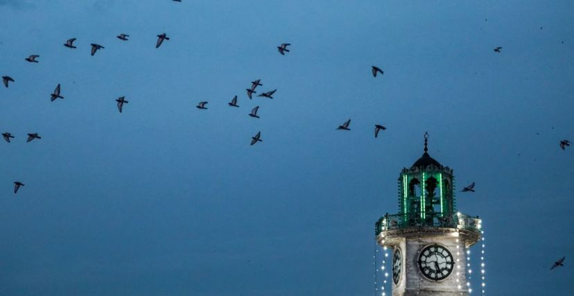 Pigeons fly past the minaret of the mosque shrine of Abdul Qadir al-Kilani in Baghdad on April 21, 2023 during early morning prayers on the first day of Eid al-Fitr, which marks the end of the holy fasting month of Ramadan. (Photo by Murtaja LATEEF / AFP) (Photo by MURTAJA LATEEF/AFP via Getty Images)