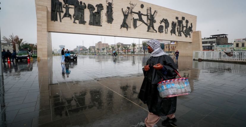 A man walks across Tahrir Square during a rain in Baghdad on December 13, 2023. (Photo by Ahmad AL-RUBAYE  AFP) (Photo by AHMAD AL-RUBAYEAFP via Getty Images)