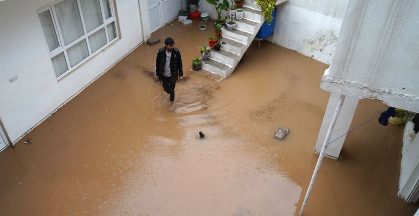 TOPSHOT - A man walks in a flooded courtyard following heavy rains in Dohuk in Iraq's northern autonomous Kurdistan region on March 19, 2024. (Photo by Ismael ADNAN / AFP) (Photo by ISMAEL ADNAN/AFP via Getty Images)